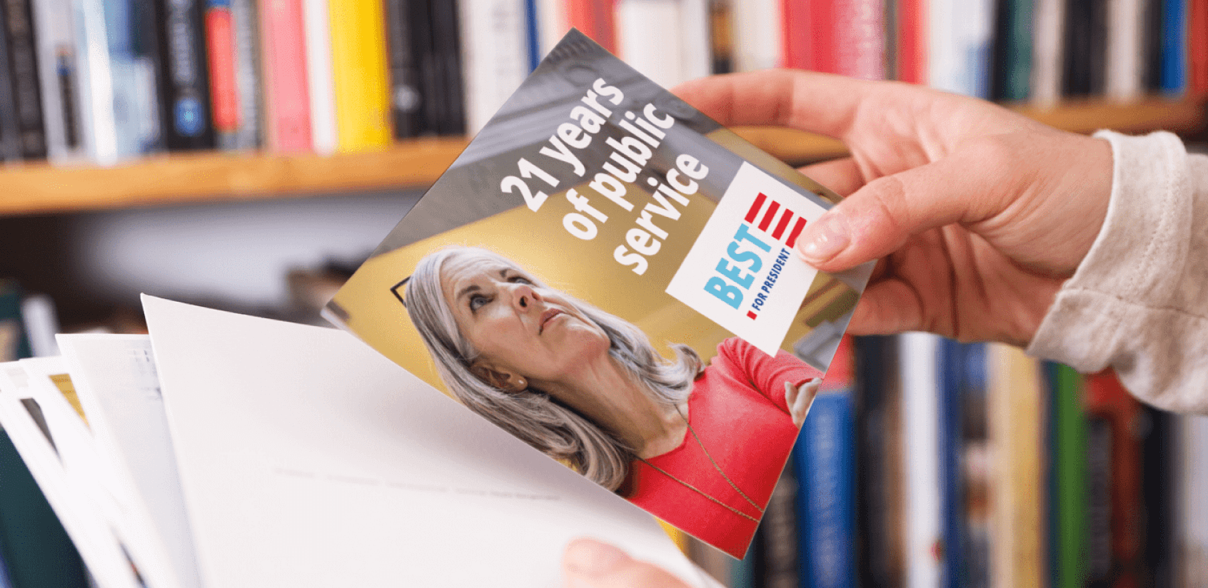 Close up of a woman’s hands holding a campaign mail piece promoting a candidate.