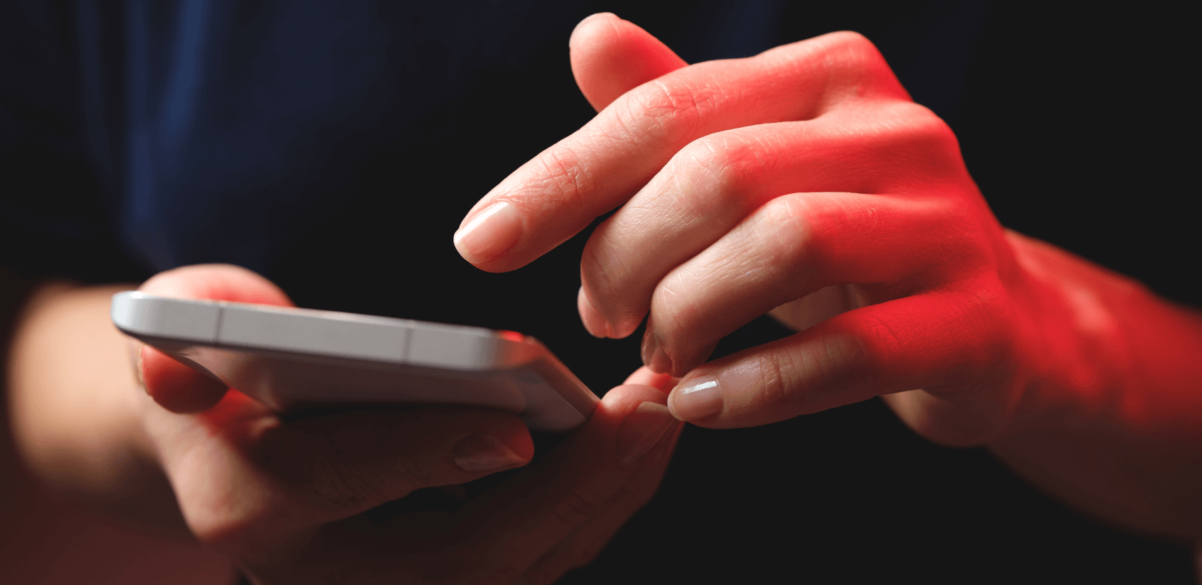 Close up of hands holding a smartphone.