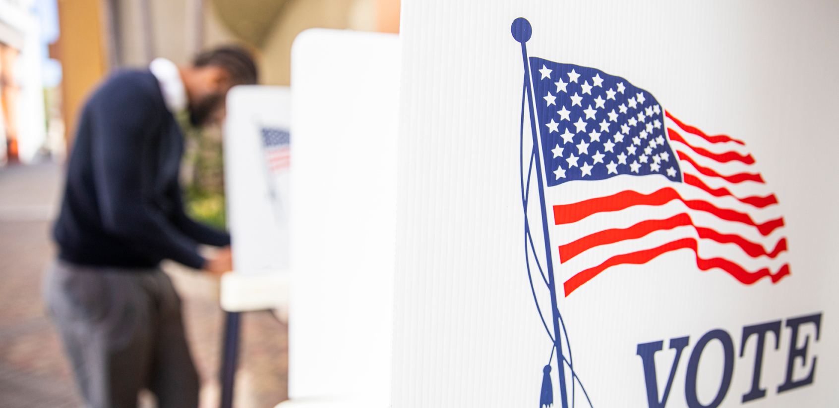 Close up of an American flag illustration on the sidewall of a row of voting booths.